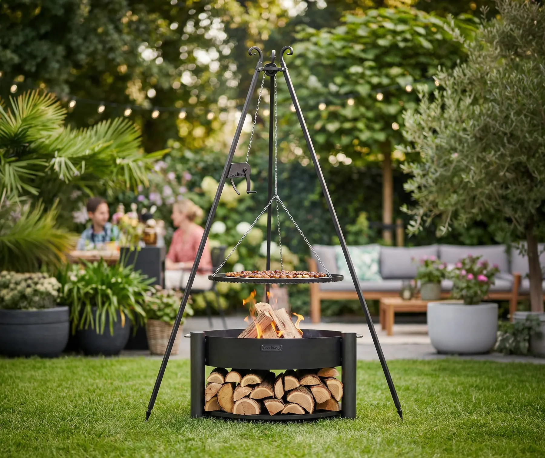 COOK KING tripod grill over a fire bowl in a garden